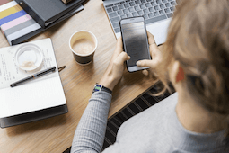 An aerial look at woman at her desk on her phone